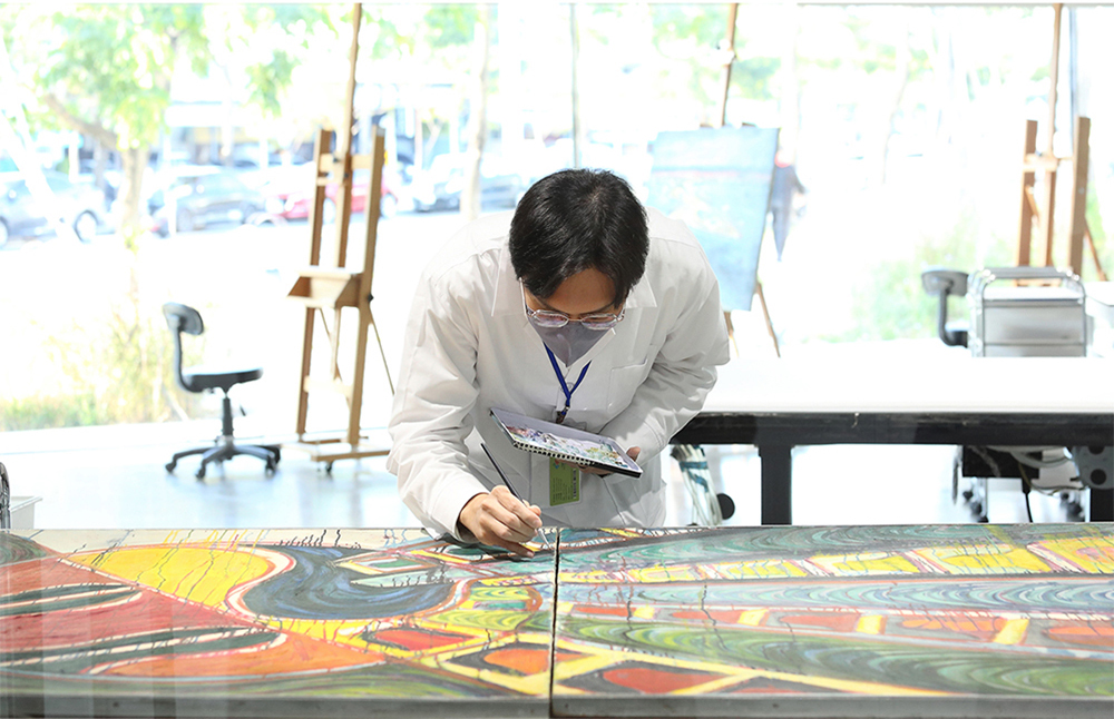 專業修復師細膩地修補畫家曾培堯的作品《生命694》。(攝影/Carter)