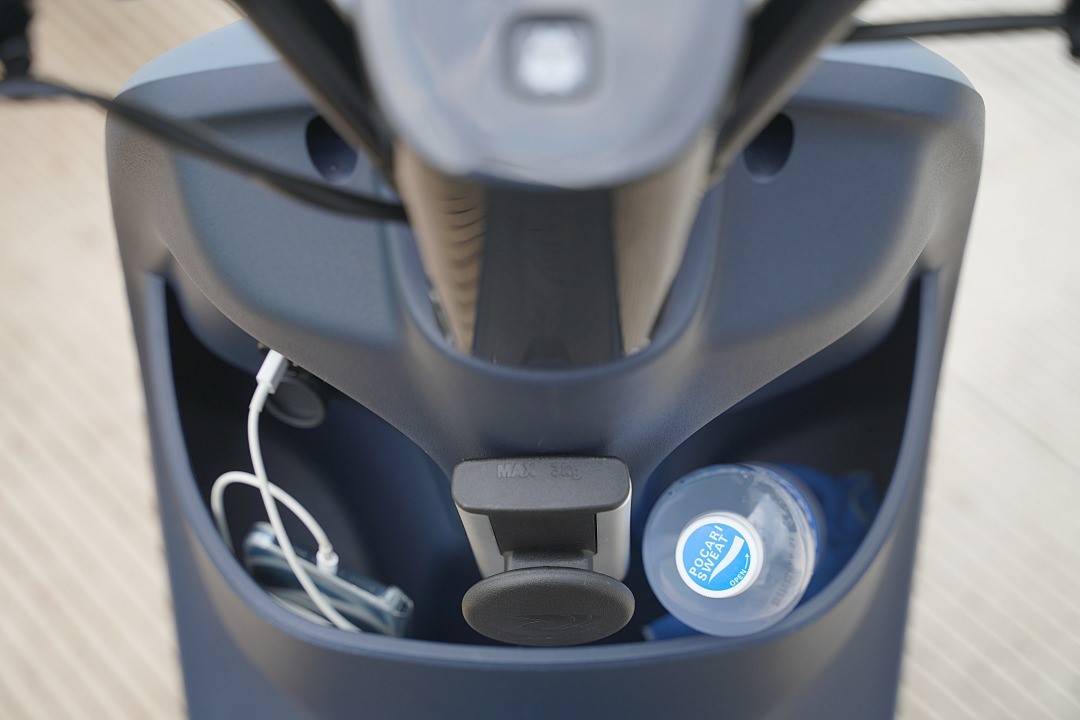 置物箱放入一瓶 600cc. 飲料以及充電中的手機，空間依然綽綽有餘。