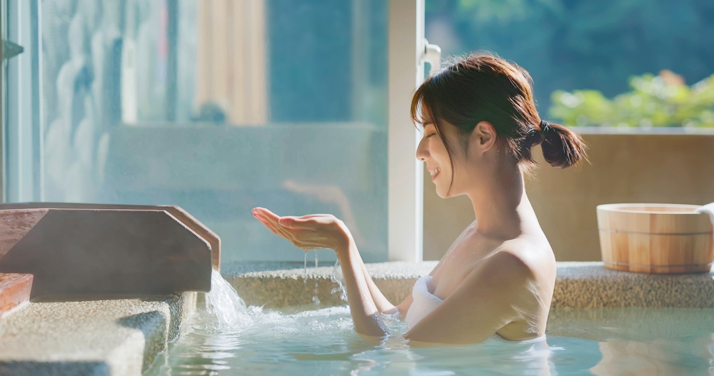 Slow,Motion,Of,Asian,Woman,Scoop,Up,Hot,Spring,By