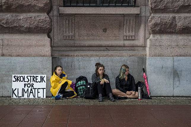 Siswa Swedia berumur lima belas tahun, Greta Thunberg, memimpin aksi sekolah dan duduk di luar Riksdagen, gedung parlemen Swedia, untuk meningkatkan kesadaran akan perubahan iklim pada 28 Agustus 2018 di Stockholm, Swedia.[MICHAEL CAMPANELLA / Getty Images/Business Insider]