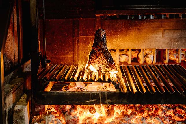 WILDWOOD回歸人類最原始的烹調方式，以原木生火燒烤自家乾式熟成肉品、在地食材與鮮活海鮮，完美帶出食材自然鮮味。從即日起至4月20日點原木燒烤乾式熟成系列牛排，招待酥脆中卷一份。（圖片提供／WILDWOOD）