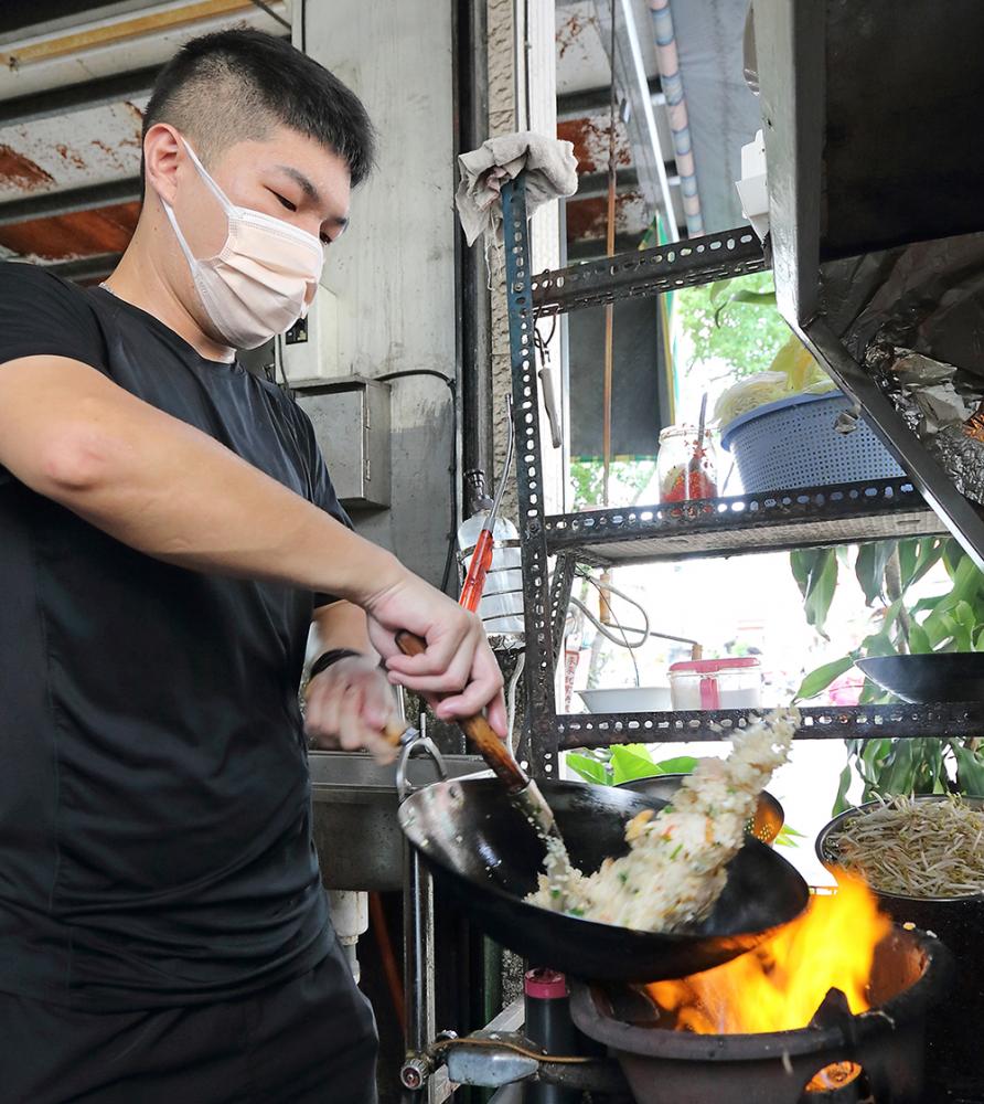 爐台前年輕二代老闆身手矯健俐落，三兩下就盛上香噴噴、粒粒分明的蝦仁炒飯。(攝影/Carter)