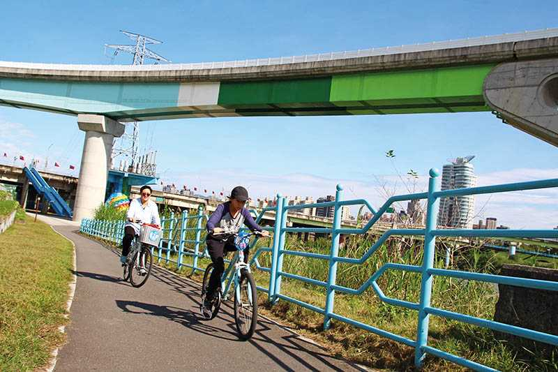 在攝影族喜歡取景的新店溪高架軌道下，騎車追捷運、賞河景，別有一番樂趣。（圖／楊麗雯攝影）