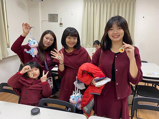 大陸新住民亮亮(左二)和她的女兒們開心地拿著良緣吉利微刺繡鑰匙圈合照。（圖片來源／移民署提供）