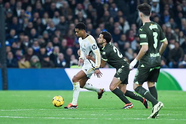 Real Madrid's Jude Bellingham (L) breaks through during the La Liga match against Girona in Madrid, Spain, Feb. 10, 2024. (Photo by Gustavo Valiente/Xinhua)