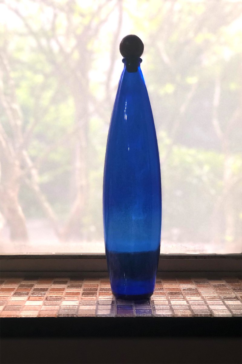 有小丑紅鼻子木塞的藍色長玻璃瓶