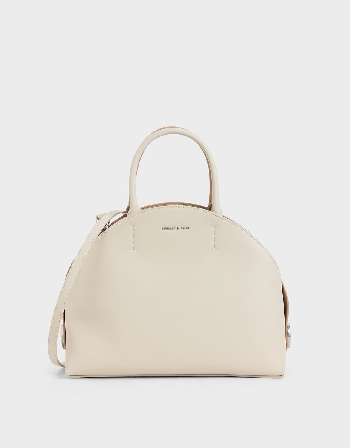 簡約立體的剪裁有著令人意想不到的雙面配色，淡雅色澤搭配金屬圓扣，洋溢著都會女郎的率性感。