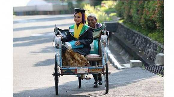 Raeni menuju Auditorium Unnes untuk mengikuti wisuda diantar Ayahnya, Mugiyono, Selasa (10/6/2014).